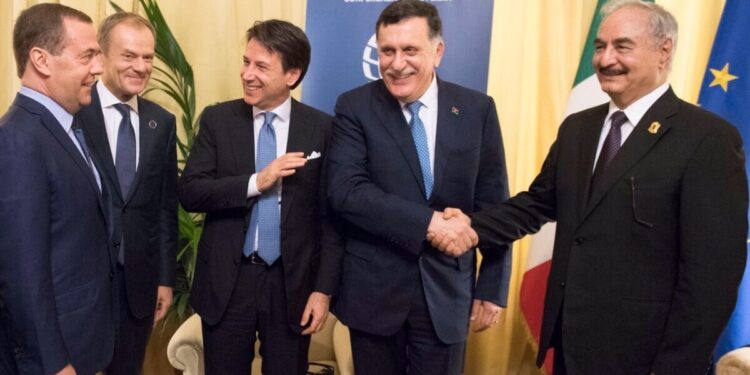 stretta di mano tra Sarraj e Haftar