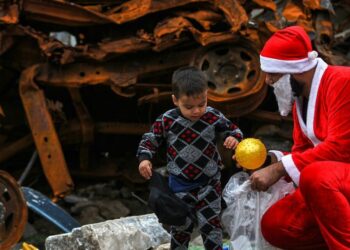 Un giovane iracheno vestito da Babbo Natale distribuisce regali nella città vecchia di Mosul (LaPresse)