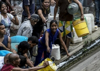 Venezuelani raccolgono l'acqua (LaPresse)