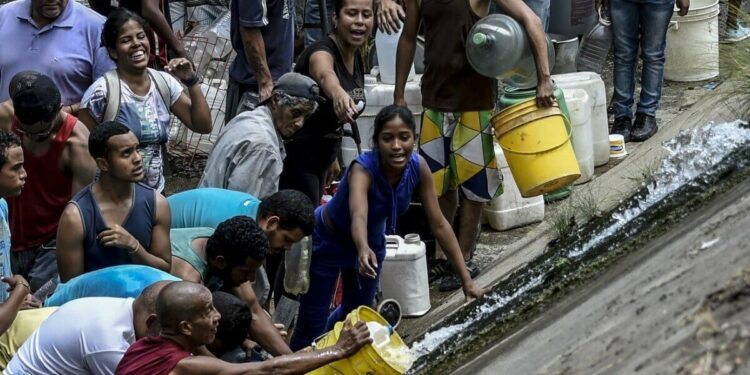 Venezuelani raccolgono l'acqua (LaPresse)