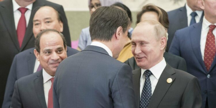 Il premier Giuseppe Conte (di spalle) a Pechino tra al Sisi e Putin (LaPresse)