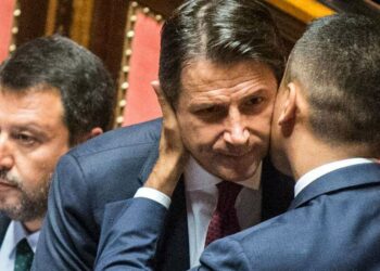 Luigi Di Maio abbraccia Giuseppe Conte; dietro, Matteo Salvini (LaPresse)