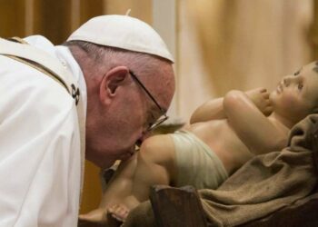 Papa Francesco bacia Gesù bambino durante la Messa di Natale (LaPresse)