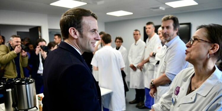 Il presidente francese E. Macron con lo staff medico dell'ospedale Pitie-Salpetrière di Parigi (LaPresse)