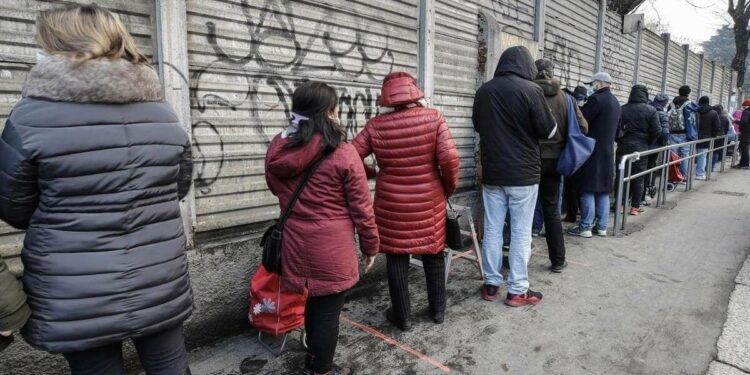 Milano, coda per la consegna di beni alimentari di prima necessità (LaPresse)