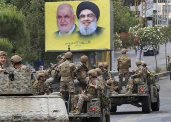 Forze dell'esercito libanese davanti al manifesto di Hezbollah Hassan Nasrallah, a destra, e del capo del blocco parlamentare Mohammed Raad (LaPresse)