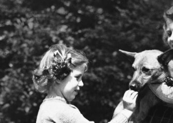 Luglio 1936: la Principessa Elisabetta, a destra, tiene un Corgi del Pembrokeshire mentre sua sorella, la Principessa Margaret, gli dà da mangiare un biscotto. (LaPresse)