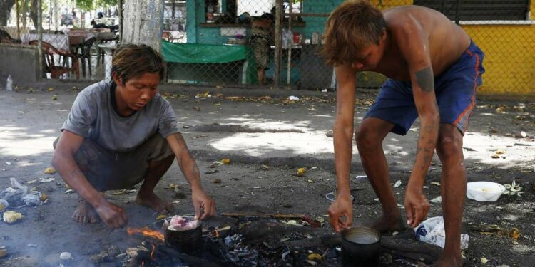 Alcuni Yanomami cucinano per le strade di Boa Vista (Lapresse)