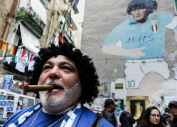 A Napoli, quartieri spagnoli, sotto il murales di Maradona (LaPresse)