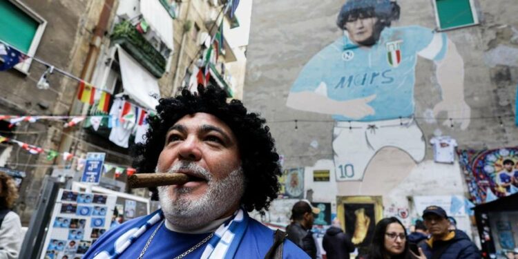 A Napoli, quartieri spagnoli, sotto il murales di Maradona (LaPresse)