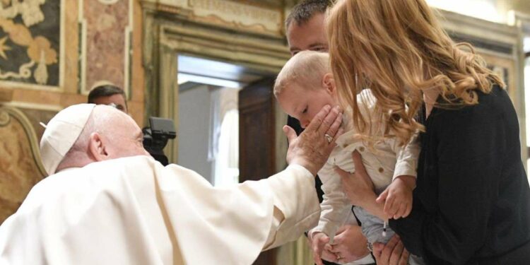 Papa Francesco con una giovane famiglia (LaPresse)